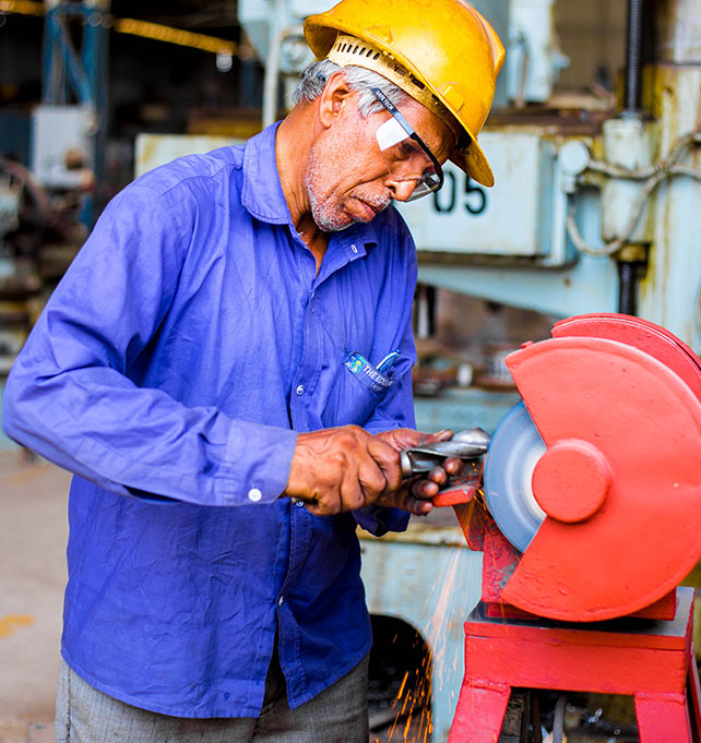 Man grinding metal part Man grinding metal part